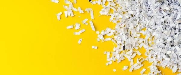 Geschredderte Dokumente auf gelber Ablage